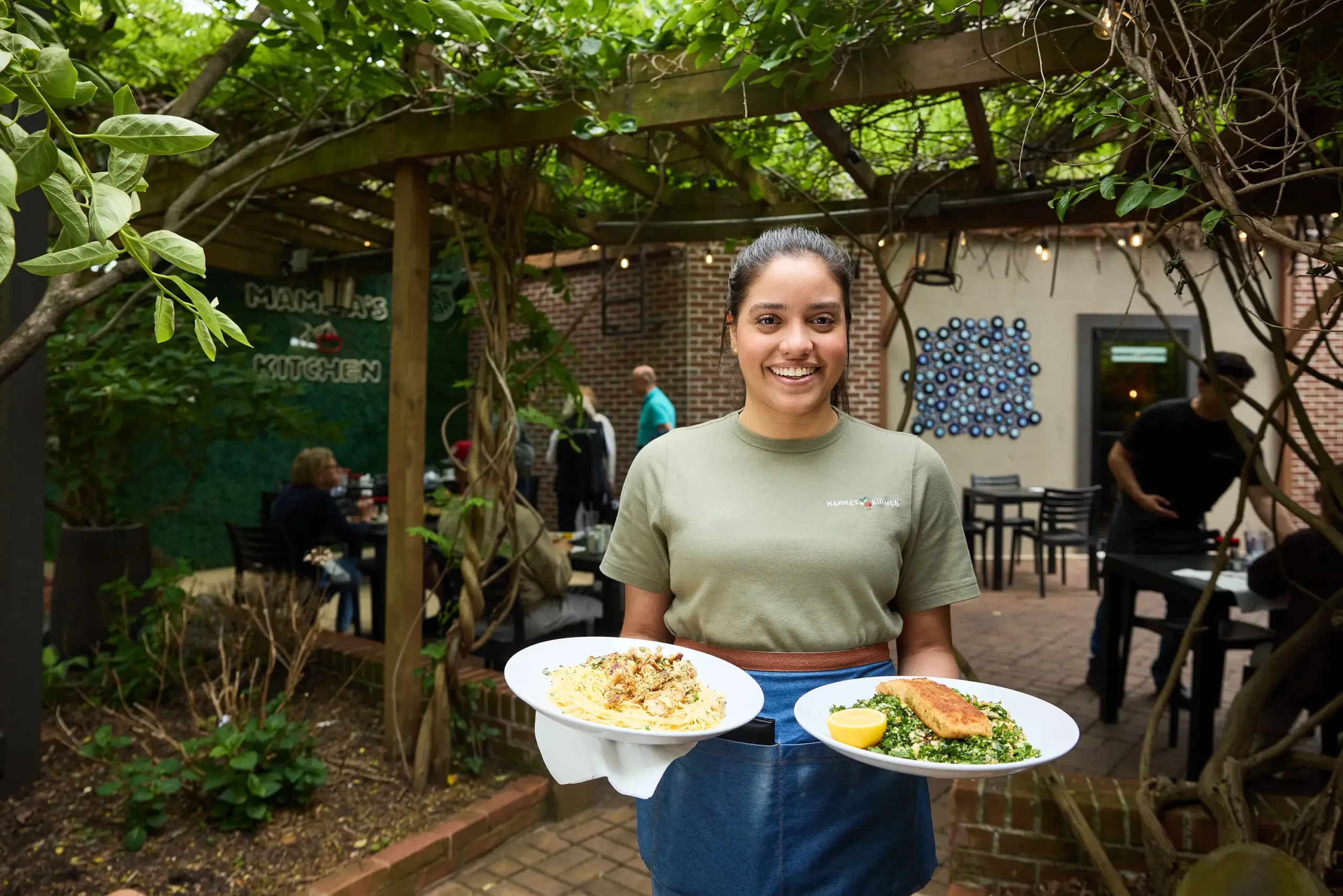 food-mamas-kitchen-alt-fairfax-va A woman holding two plates of food