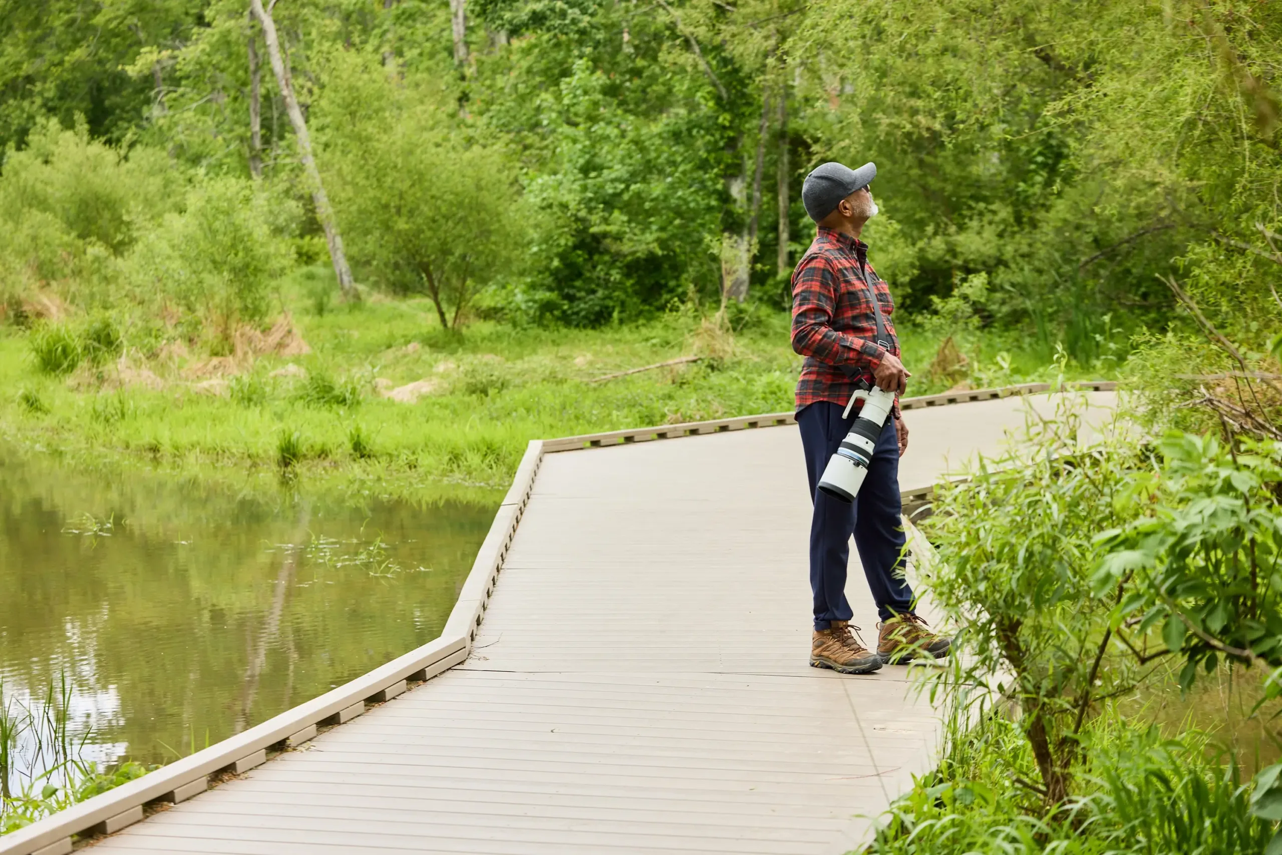 A man on a boardwalk with a camera at his hip