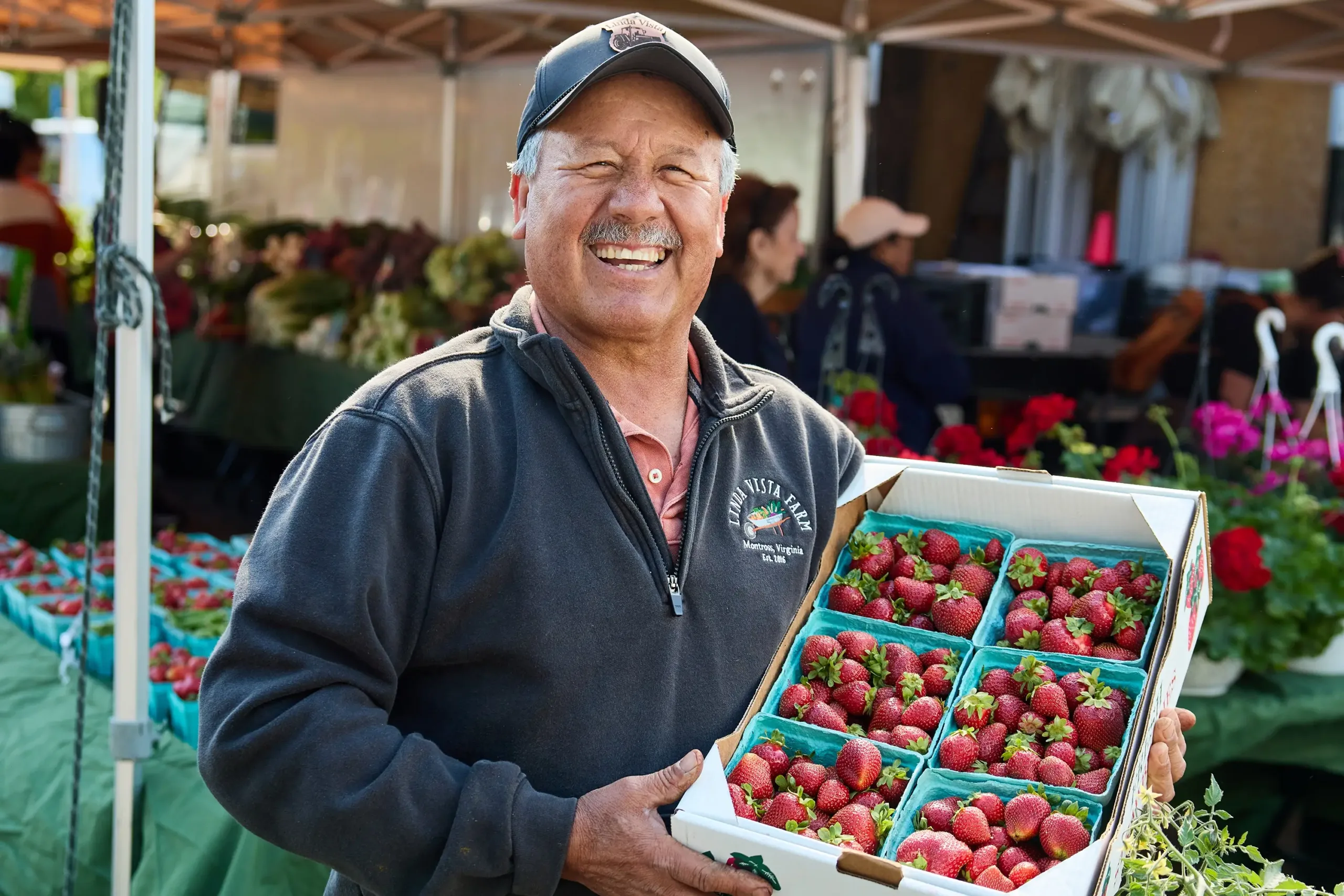 A man holding a box of strawberries
